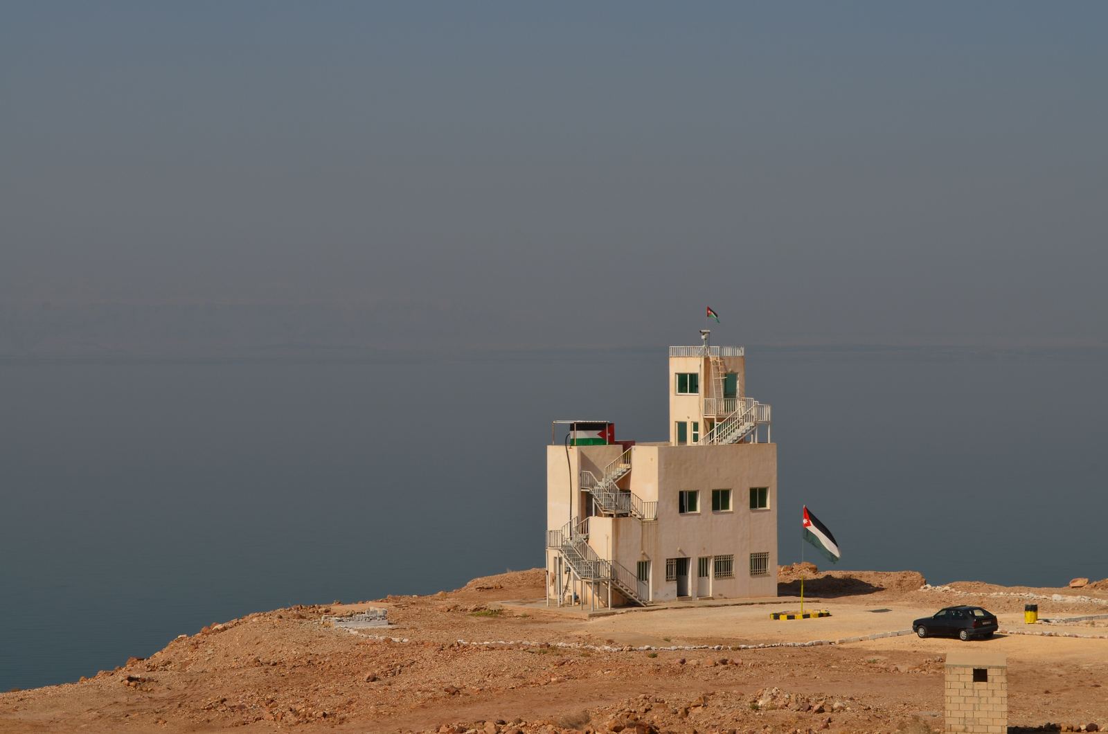 Calm Dead Sea water with salt deposits along the shore on the Jordanian side