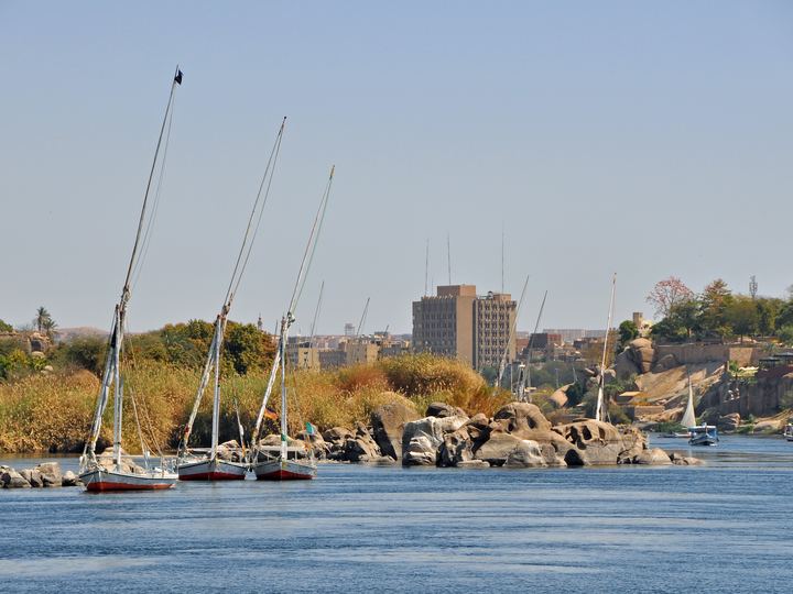 Feluccas with white sails on the Nile at Aswan with desert hills behind