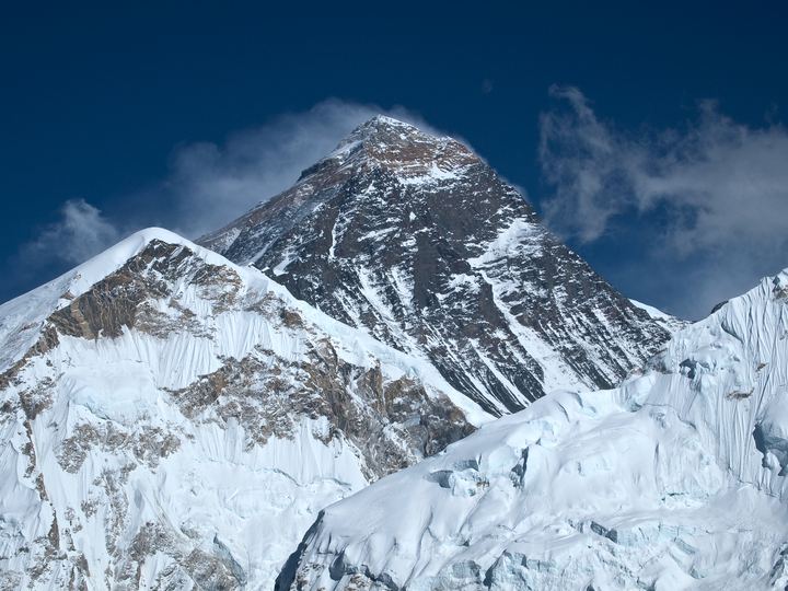 The summit pyramid of Mount Everest above surrounding Himalayan peaks