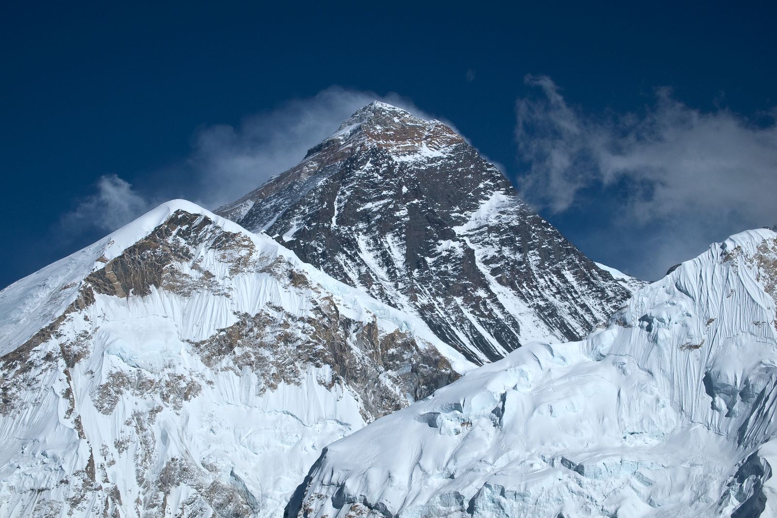 The summit pyramid of Mount Everest above surrounding Himalayan peaks